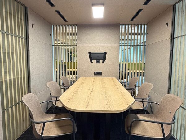 VOX Large met privacy-lamellen, ingericht met vergadertafel, stoelen en scherm.