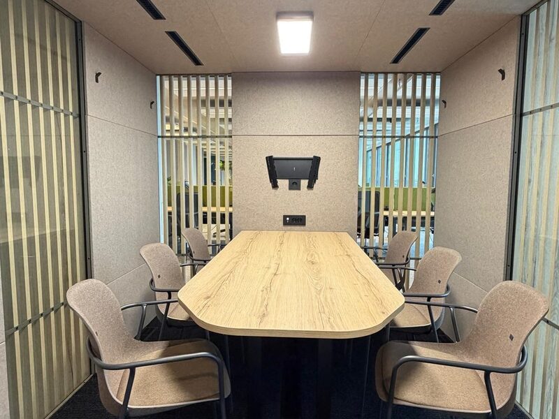 VOX Large met privacy-lamellen, ingericht met vergadertafel, stoelen en scherm.